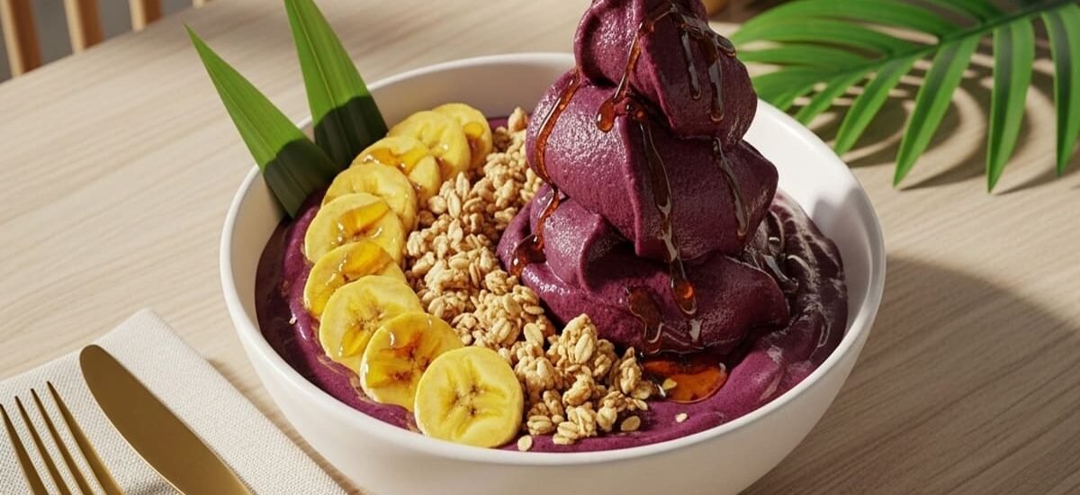 Tigela de açaí cremoso decorada com granola crocante e bananas frescas — sobremesa gelada e nutritiva.